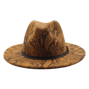 Detail of wide brim fedora hat featuring brown snakeskin print and black decorative band