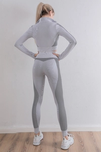 Vue détaillée du dos d'un ensemble de yoga gris avec bandes latérales noires sculptantes