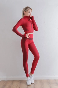 Détail d'un ensemble de yoga côtelé rouge avec haut zippé manches longues et legging taille haute