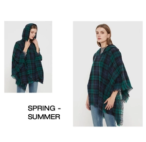 Detail view of plaid hooded poncho with tassel hem in dark green and navy blue knit