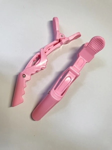 Close-up of pink sectioning crocodile hair clips with non-slip texture for salon styling