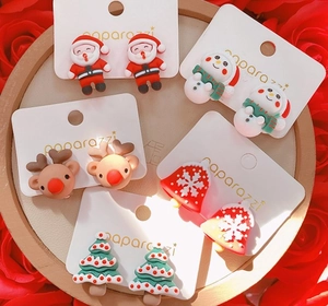 Detailed view of five pairs of festive resin Christmas earrings with Santa and reindeer