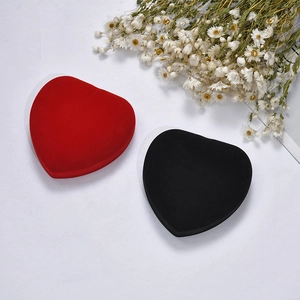 Close-up of heart-shaped velvet jewelry boxes in red and black for necklaces