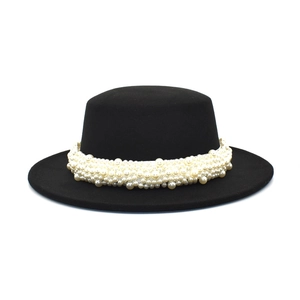 Détail du chapeau plat en feutre de laine noir avec bande décorative en perles élégantes