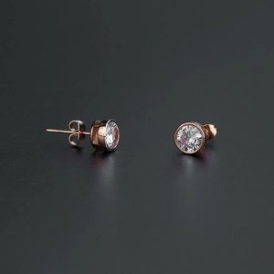 Vue macro des boucles d'oreilles en or rose avec zircone ronde et serti à griffes