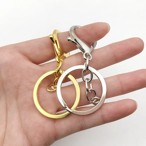 Gold and silver metal keychain sets with lobster clasps and chains held by hand