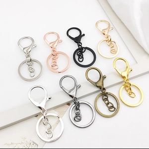 Close-up of various metal keychain components with lobster clasps in multi-color finishes