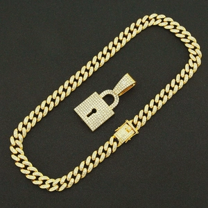 Close-up of golden iced-out Cuban chain and lock pendant with sparkling crystals