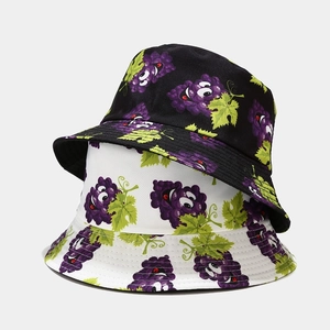 Detail of stacked fisherman hats featuring purple grape prints on cotton fabric textures