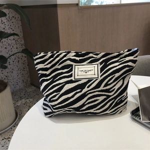 Detail of canvas zebra pattern makeup bag with a sewn-in 'TIME TO PARTY' label on top