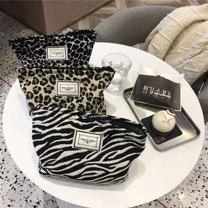 Detailed view of canvas makeup bags with animal prints and Time to Party labels