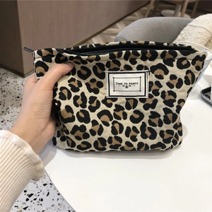 Detail of leopard print canvas toiletry bag with zipper and Time to Party label