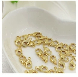 Detailed view of 14K gold-plated lobster clasps scattered in a white heart-shaped tray