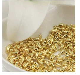 Detailed view of 14K gold-filled daisy pendant charms with cubic zirconia in a ceramic bowl