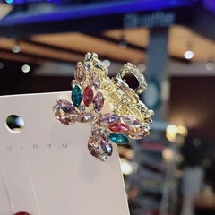 Detailed close-up of a butterfly hair claw clip with colorful inlaid gemstones on a metal base