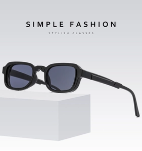 Detail of black rectangular sunglasses with geometric temples on white pedestal