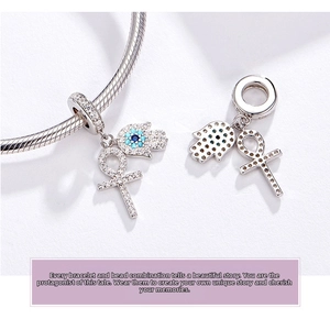 Macro view of S925 sterling silver Hamsa hand and Ankh cross charms with blue zircons