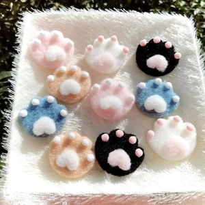 Detailed view of colorful plush cat paw brooches in soft pink blue and white fur
