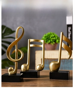 Detailed view of matte gold musical note statues on black bases for home office decor