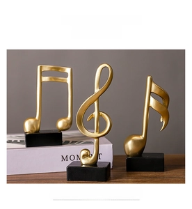 Detailed view of three golden resin music note statues on black cubic bases