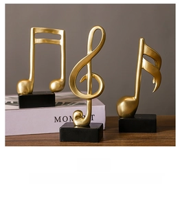 Three golden resin musical note ornaments on black bases for modern tabletop decor