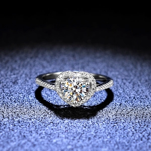 Bague coeur en argent 925 avec moissanite et monture halo sur fond bleu luxueux