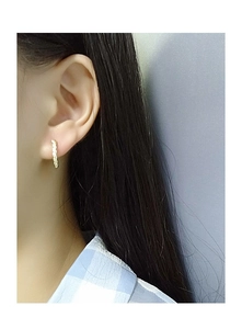 Close-up of golden sterling silver hoop earrings with pave cubic zirconia on female ear