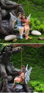 Detail of miniature resin flower fairy couple sitting on a green leaf swing ornament