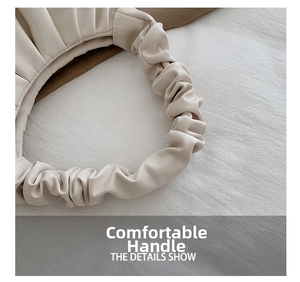 Close-up of comfortable ruched handle on a beige cloud pleated shoulder bag for women