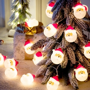 Warm white LED Christmas string lights with Santa Claus heads on a snow-covered tree