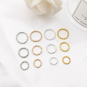 Detailed view of hammered alloy hoop pendants in gold, silver, and rose gold finishes
