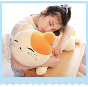 Close-up of soft plush cat long pillow with orange spots and embroidered facial features