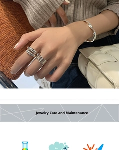 Detail of silver wavy open rings and minimalist twisted bracelet on a model
