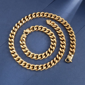 Flat lay of gold Cuban link chain necklace and bracelet set on dark blue background