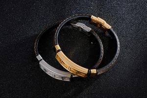 Detailed view of woven leather bracelets with gold and silver engraved metal hardware