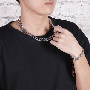 Detail of silver cuban link chain necklace and bracelet set on male model