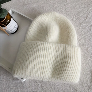 Detailed view of the soft rabbit fur knit texture on this cream white winter beanie hat