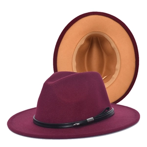 Detail of burgundy wool fedora hat featuring a contrasting camel brim and black leather band