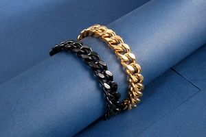 Close-up of black and gold Cuban link chains wrapped on blue cylinder pedestals