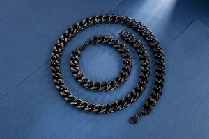 Detail of matte black Cuban link chain set with lobster clasp on dark background