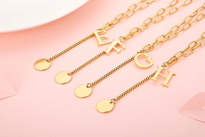 Detailed view of gold stainless steel necklaces with E, F, G, H letter pendants and round tags