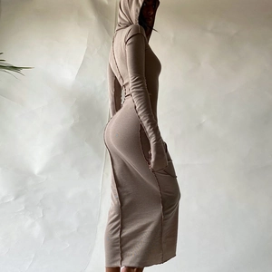 Detail of khaki ribbed knit hooded dress featuring prominent exposed seam stitching