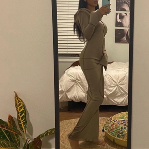 Detail of khaki long sleeve hooded dress showing ribbed knit fabric and exposed seam lines