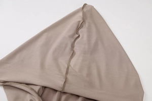 Close-up of beige ribbed fabric texture and professional seam detail on slim-fit dress