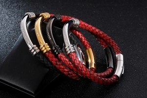 Close-up of woven leather bracelets with curved metal tubes and magnetic clasps