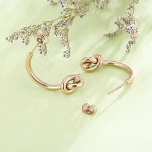 Élégantes boucles d'oreilles nœud en acier titane doré pour femmes au design minimaliste