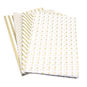 Gold and white patterned tissue paper featuring stripes, polka dots, and star designs for gifts