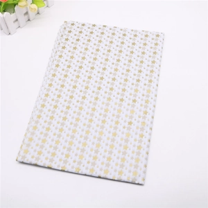 Detail of folded white wrapping paper with golden and beige star patterns for bouquets
