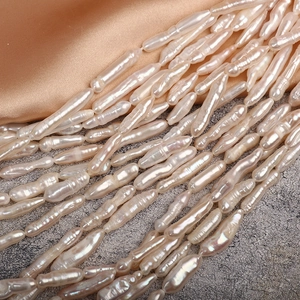 Lustrous natural baroque freshwater stick pearls arranged on premium champagne silk fabric