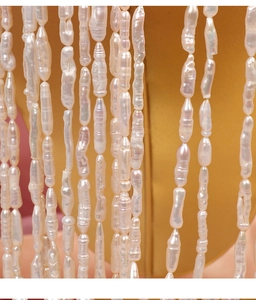 Macro shot of natural baroque toothpick pearls with strong luster on a gold stand